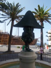 Figuren El Enano placeret på pladsen Alameda foran Columbus skib